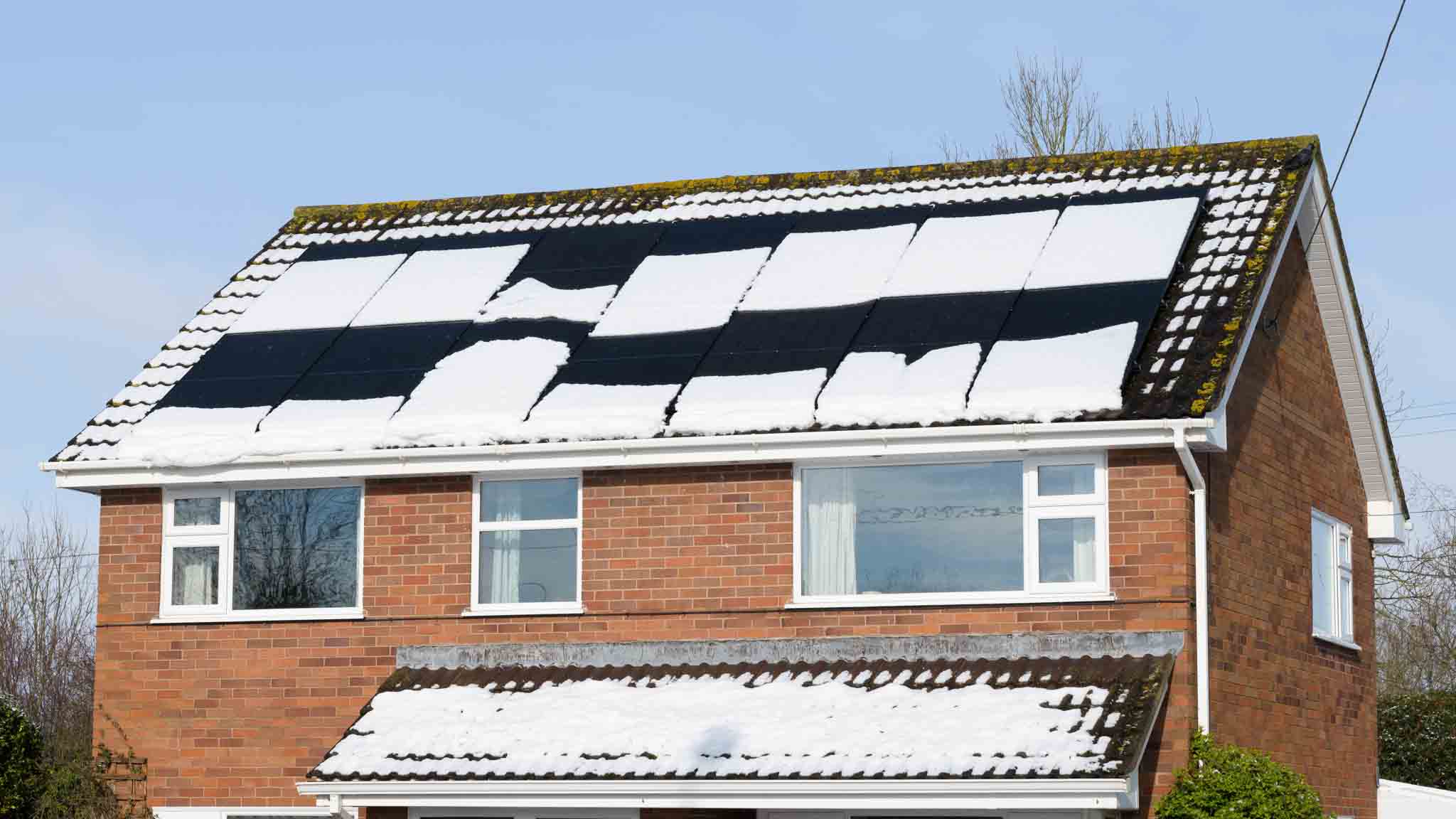 Two,Story,House,In,England,With,Snow,Sliding,From,Roof