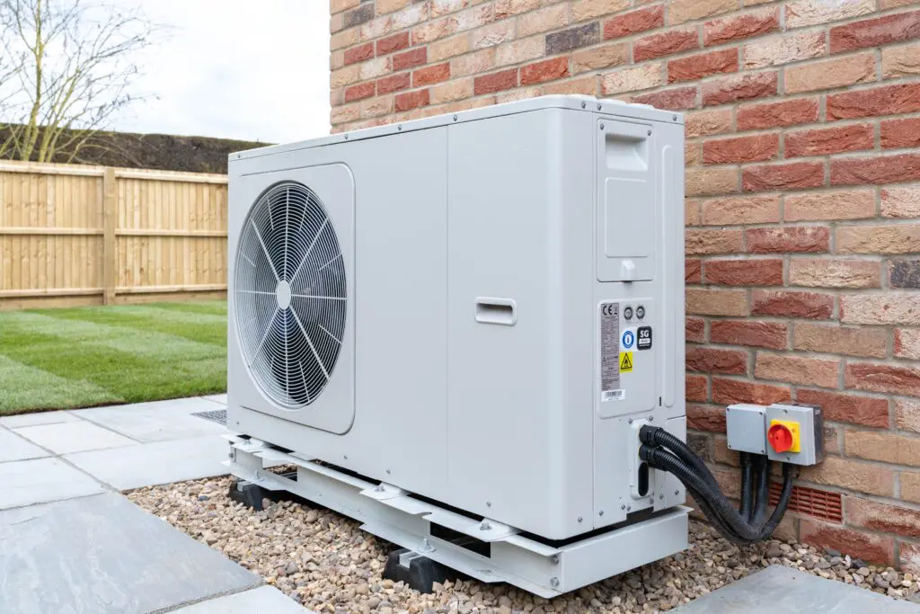 air source heat pump outside modern house in garden