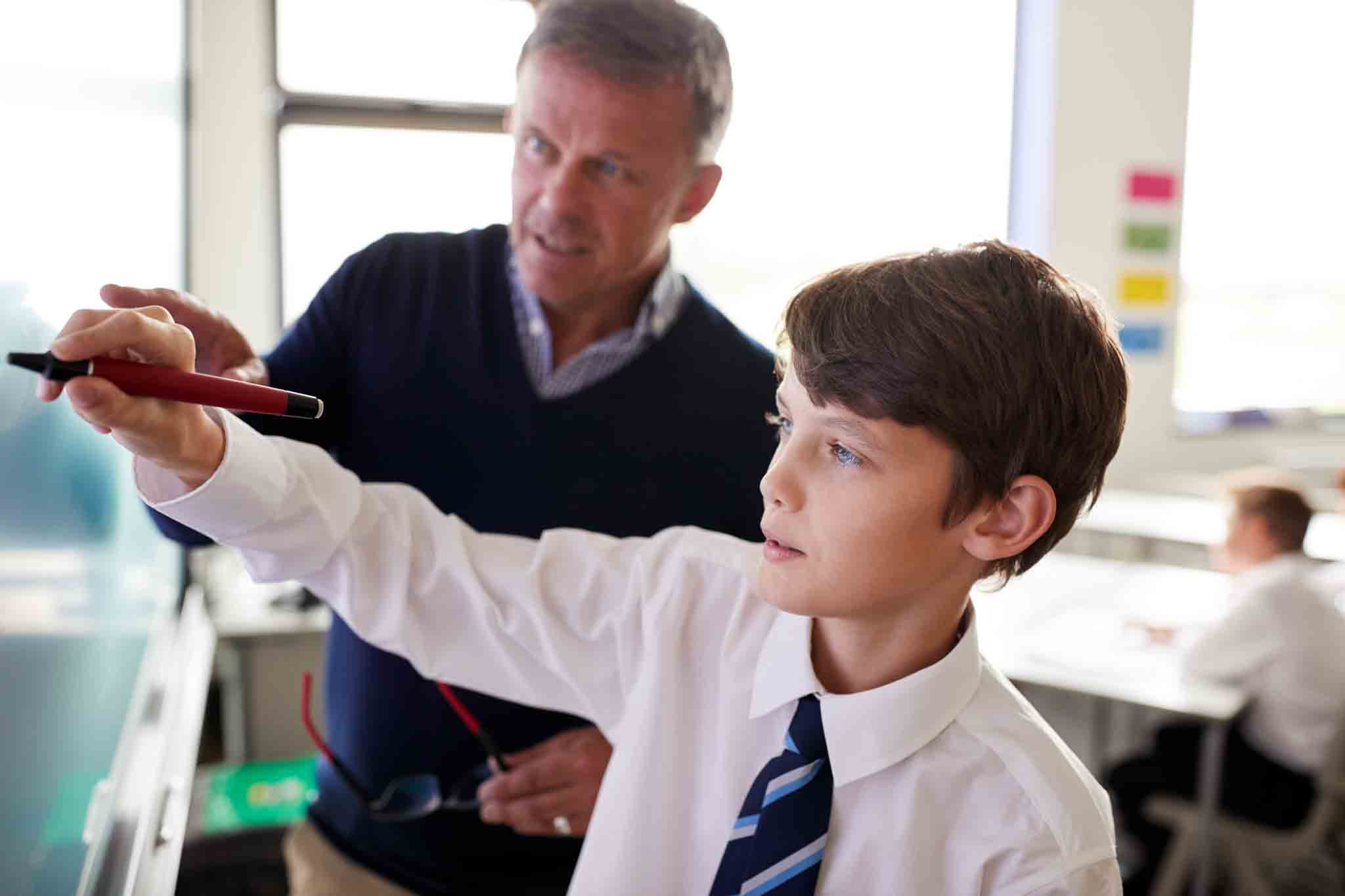 School-boy-writing-on-whiteboard