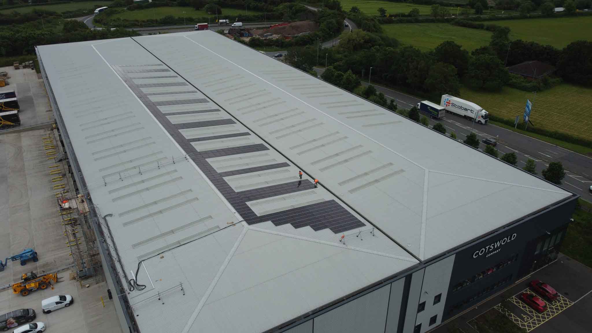 solar installers on warehouse rooftop